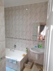 a bathroom with a tub and a sink at Clivia Guesthouse in Pietermaritzburg