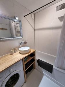 a bathroom with a sink and a washing machine at T2 Cosy climatisé 5 min aéroport in Blagnac