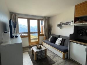 a small living room with a couch and a window at Appartement Huez, 2 pièces, 4 personnes - FR-1-405-173 in L'Alpe-d'Huez