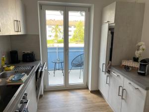 une cuisine avec une porte menant à un balcon dans l'établissement AM Fleurystr, ALL NEW, komfortabel, ZENTRAL in Amberg!!!, à Amberg