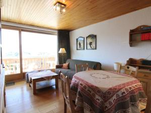 ein Wohnzimmer mit einem Tisch und einem Sofa in der Unterkunft Appartement Huez, 1 pièce, 5 personnes - FR-1-405-200 in Huez