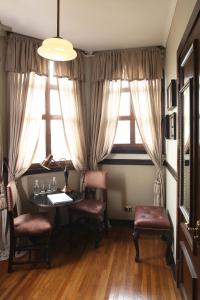 Habitación con mesa, sillas y ventana en Hotel Boutique Castillo Rojo, en Santiago