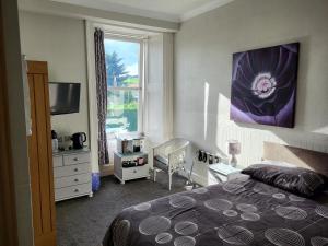 sypialnia z łóżkiem i oknem w obiekcie Macbeth Arms w mieście Lumphanan