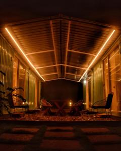 a patio with chairs and a table at night at Clapping Leaves Resort in Hyderabad