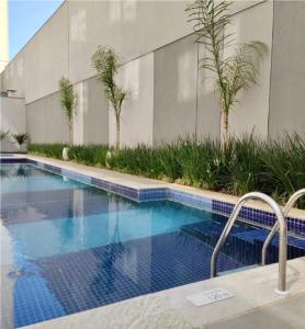 a swimming pool with palm trees next to a building at MV 77A Incrível Apartamento Em Frente Ao Metrô Brás ! - Rua Coronel Mursa, 56 - Bras in Sao Paulo
