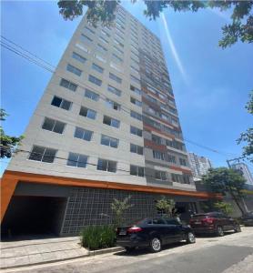 un edificio alto con macchine parcheggiate di fronte di Incrível Apartamento Em Frente Ao Metrô Brás ! a San Paolo