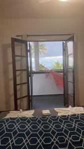 a bedroom with an open door with a view of the ocean at Pousada Kai in Itanhaém