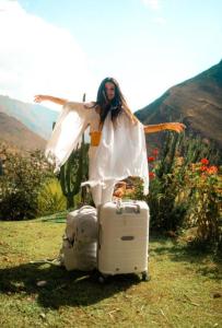 a woman is standing next to a pile of luggage at Wolf Totem Steam Punk Loft Villa in Pisac