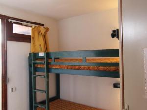 a bunk bed with a ladder in a room at Appartement Huez, 1 pièce, 4 personnes - FR-1-405-183 in LʼHuez