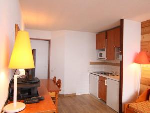 a small kitchen with a desk with a lamp on it at Appartement Huez, 1 pièce, 4 personnes - FR-1-405-183 in LʼHuez
