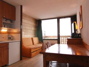 a kitchen and living room with a couch and a table at Appartement Huez, 1 pièce, 4 personnes - FR-1-405-183 in LʼHuez
