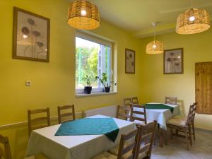 a dining room with two tables and a window at Írisz Panzió in Budapest