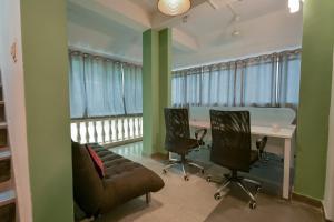 an office with a couch and chairs and a table at Snore Summore, Hostel in Koramangala in Bangalore