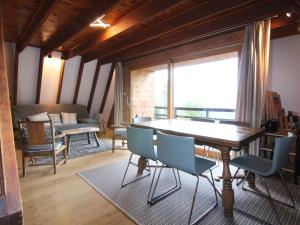 a living room with a table and chairs and a large window at Chalet Huez, 3 pièces, 6 personnes - FR-1-405-184 in LʼHuez