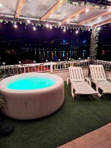 a hot tub with two chairs and a table at Stone House Entre os Rios in Entre -os- Rios