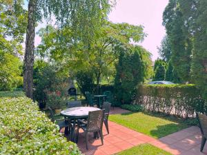 eine Terrasse mit einem Tisch und Stühlen im Garten in der Unterkunft Írisz Panzió in Budapest