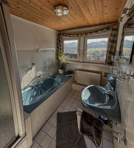 La salle de bains est pourvue de 2 lavabos et d'une baignoire. dans l'établissement Ferienwohnung Smuda, à Bad Laasphe