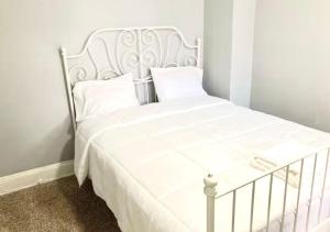 a white bed with white sheets and pillows at Clover 2900 - Apartment and Rooms with Private Bathroom near Washington Ave South Philly in Philadelphia