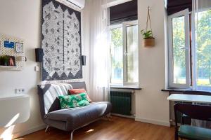 ein Wohnzimmer mit einem Stuhl und 2 Fenstern in der Unterkunft Затишні дворівневі смарт апартаменти in Bila Zerkwa