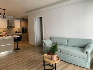 a living room with a blue couch and a table at Just like Home in Sitia