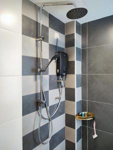 un bagno con doccia e piastrelle bianche e nere di 7&9 Manhattan Condominium Ipoh a Ipoh