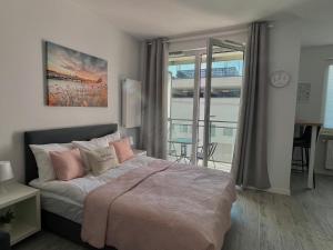 Ένα ή περισσότερα κρεβάτια σε δωμάτιο στο Studio Apartment Raspberry by Galeria Północna