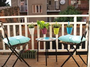 two chairs and a table on a balcony with potted plants at Apartment Witty Please in Zagreb