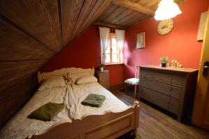 1 dormitorio con 1 cama grande en una habitación de color rojo en Resetówka - w dzień wyjazdu zostań do wieczora, en Brenna