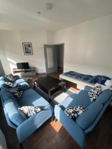 una sala de estar con sofás azules y una mesa. en Gruppenunterkunft Bremerhaven, en Bremerhaven
