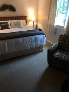 een slaapkamer met een bed, een bank en een stoel bij Plush garden level apartment near Stowe in Morristown