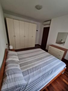 uma cama grande num quarto com armários brancos em Appartamento San Siro Stadio Fiera Milano City Life em Milão