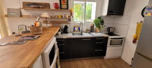uma pequena cozinha com um balcão de madeira e um lavatório em Le Repaire de la Cadière à 5mn des plages ! em Saint-Cyr-sur-Mer
