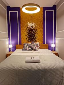a bedroom with a large bed with a yellow wall at Apartamentylove - Apartament Żwirki, prywatny parking opcjonalnie in Łódź