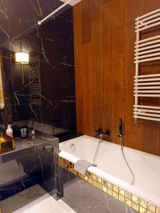 een badkamer met een bad in de kamer bij Apartamentylove - Apartament Żwirki in Łódź