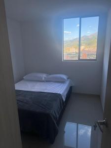 - une petite chambre avec un lit et une fenêtre dans l'établissement Hermoso Apto con Vista al Ciudad y Parqueadero Gratis, à Bello