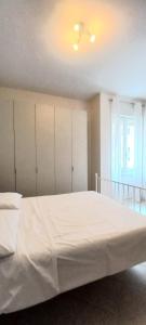 een slaapkamer met een groot wit bed en een raam bij Brixia Gallery Home in Brescia