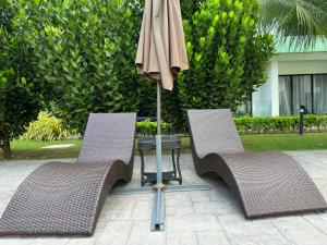 two chairs and a table with an umbrella at 7&9 Manhattan Condominium Ipoh in Ipoh