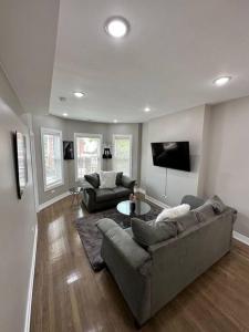 a living room with two couches and a tv at Exec Lux home wth 3 Level,6 Bdrms/3bth & 2 Kitchen in Chicago