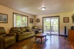 uma sala de estar com um sofá e uma mesa em Riverfront Covington Cabin with Deck and Fire Pit! em Piqua