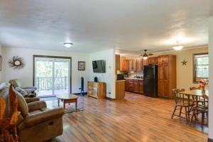 a kitchen and living room with a couch and a table at Riverfront Covington Cabin with Deck and Fire Pit! in Piqua
