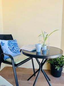 a table with a laptop and a chair with plants at Studio with sea view in Cascais in Cascais