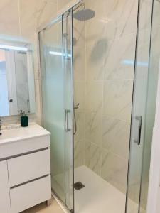 La salle de bains est pourvue d'une douche en verre et d'un lavabo. dans l'établissement Studio with sea view in Cascais, à Cascais