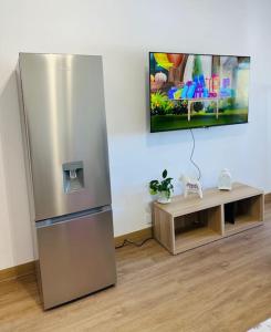 a stainless steel refrigerator in a room with a table at Studio with sea view in Cascais in Cascais