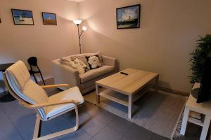 uma sala de estar com um sofá e uma mesa de centro em Cosy flat with 180cm wide very comfortable bed em Sandefjord