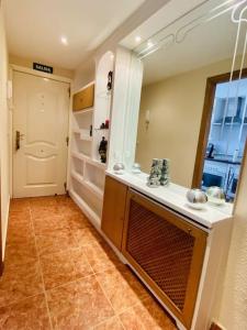 ein Bad mit einem Waschbecken und einen Flur mit einer Tür in der Unterkunft Dúplex pareado con zona exterior in Navalcarnero + 15 Fotos