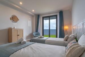 1 dormitorio con 2 camas y una ventana con vistas al océano en Isaac Villa in Santa Cruz, en Santa Cruz