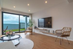 a living room with a large window and a tv at Isaac Villa in Santa Cruz in Santa Cruz