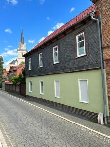 una casa verde y negra al lado de una calle en Ferienwohnung zur Hohe Str, en Bad Langensalza