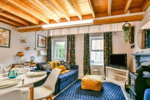 a living room with a blue couch and a tv at Fifth Milestone Annexe in York