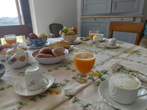 a table with breakfast foods and orange juice on it at B&b La Casa Nel Vento in Torpè